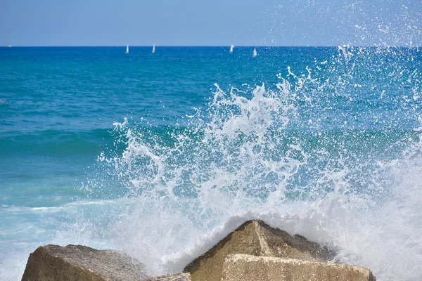 Stříkající vodě moři vlna útoku na phot rock s venkovní sluneční osvětlení — Stock fotografie