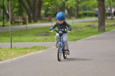 Mutlu çocuk çocuk 5 yıllık güzel sonbahar gününde bahar Park bir bisiklet ile eğleniyor. Etkin alt giyen Bisiklet kask