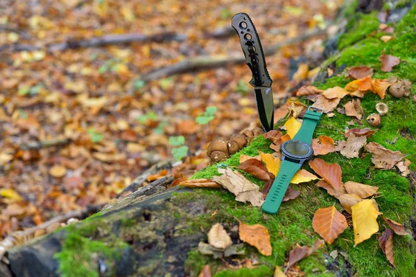 Male set - knives and watches. Black knife and smart watch in autumn forrest Royalty Free Stock Images