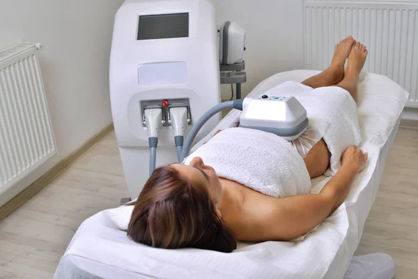 Hermosa mujer joven recibiendo tratamiento criolipolise en el gabinete cosmético — Foto de Stock