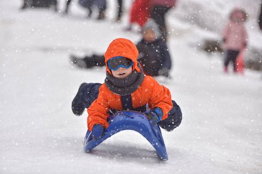 Küçük çocuk karda binme kış döneminde slaytlar