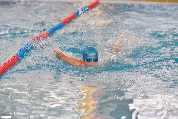 Vrije slag zwemmen kinderen racing in turkoois duidelijk overdekt zwembad — Stockfoto