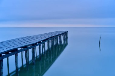 Güzel arka plan, uzun pozlama için gündoğumu görünümü önce mavi saatte ahşap köprü