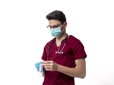 Boynunda steteskopla beyaz şırıngayla gezen genç bir erkek doktor.