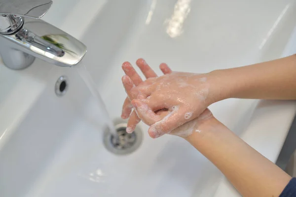 Close up of hands washing with soap. Washing hands with soap under the faucet with water. Clean and hygiene concept.