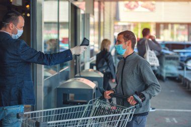 Süpermarkette ateş ve Coronavirüs belirtileri için bir termal tarayıcı..