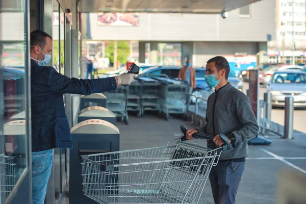 Süpermarkette ateş ve Coronavirüs belirtileri için bir termal tarayıcı..