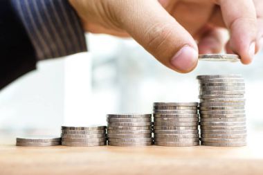 Yakın çekim, işadamı el koymak sikke yığını, Coins için para tasarrufu konseptiyle