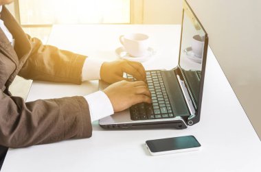 Bilgisayarda çalışıyor, iş adamının ellerini kapatıyor.