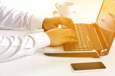 Bilgisayarda çalışıyor, iş adamının ellerini kapatıyor.