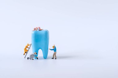 Minyatür işçi arabadaki motoru tamir etti ve kontrol etti. Bakım servisi konsepti.