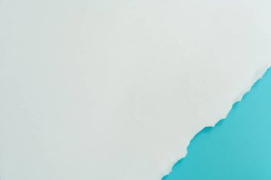 Üst manzara mavi gökyüzü beyaz ve gri arkaplan üzerine yırtılmış kağıt. Banka