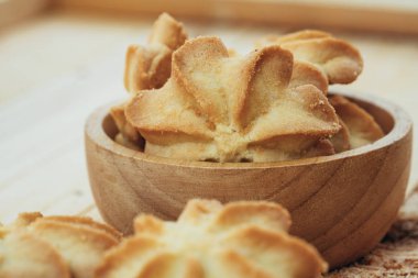 Close-up macro cookies baking on wooden bowl background.