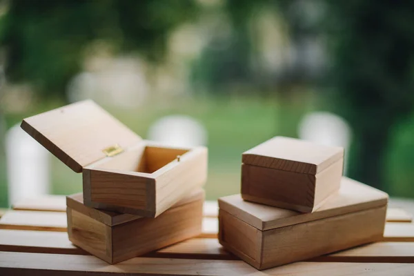Handcrafted wooden boxes on the wooden shelf and the nature on the background