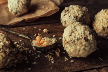 Sağlıklı çikolata enerji ısırıkları, fındıklar, tarihler, ahşap bir masada hindistan cevizi taneleri. Ev yapımı vejetaryen glütensiz sağlıklı atıştırmalıklar..