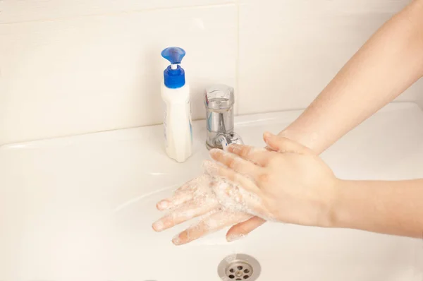 La fille se lave les mains dans la salle de bain après la rue pendant la quarantaine. Prévenir la pandémie de coronavirus, se laver soigneusement les mains à l'eau chaude et au savon antibactérien. Concept de pandémie mondiale . — Photo