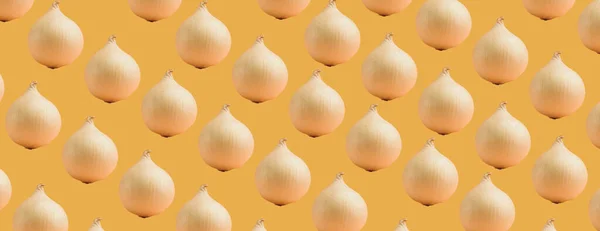 Seamless pattern of white onions on an orange background. The texture of the food.