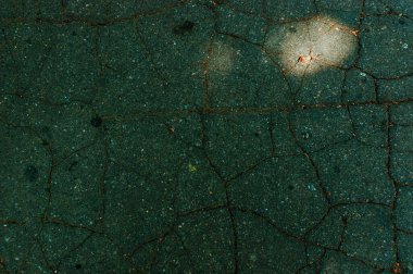 Çatlaklı siyah asfalt. Eski asfalt yolda. Koyu soyut arkaplan.