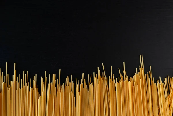 Gele Rauwe Zelfgemaakte Spaghetti Pasta Een Zwarte Betonnen Ondergrond Aan — Stockfoto