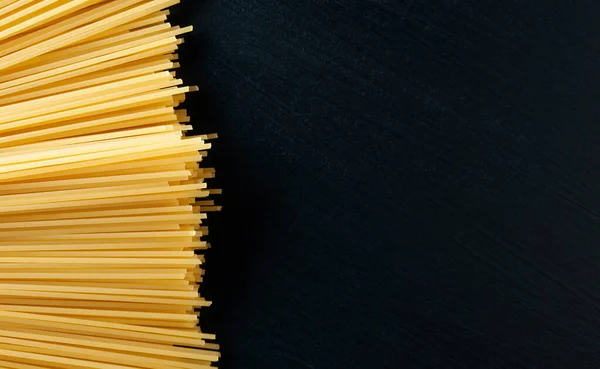 Gele Rauwe Zelfgemaakte Spaghetti Pasta Een Zwarte Betonnen Achtergrond Linker — Stockfoto