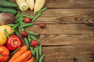 Mevsimlik meyve, sebze ve bitkilerden oluşan düz bir yer. Yaz yemekleri konsepti. Sağlıklı yaşam ve vejetaryen, vegan, diyet, temiz gıda malzemeleri. Mesaj için yer. Koyu bir ahşap arka planda yemek.