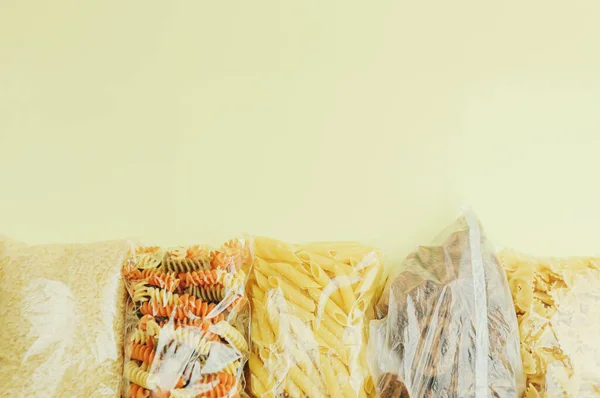 Rámeček Obrubníku Různých Potravinářských Výrobků Sáčcích Těstoviny Rýže Žlutém Pozadí — Stock fotografie