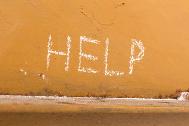 El yazısı turuncu metal zemin üzerine tebeşir ile yardım