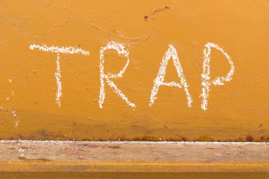 Tuzak el yazısı ile turuncu metal zemin üzerine tebeşir