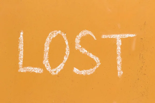 Lost handwriting with chalk on orange metal background