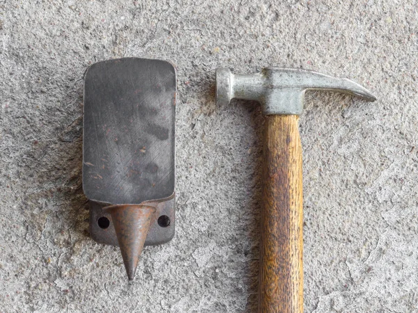 Velho pequeno martelo e bigorna em miniatura com fundo de concreto — Fotografia de Stock
