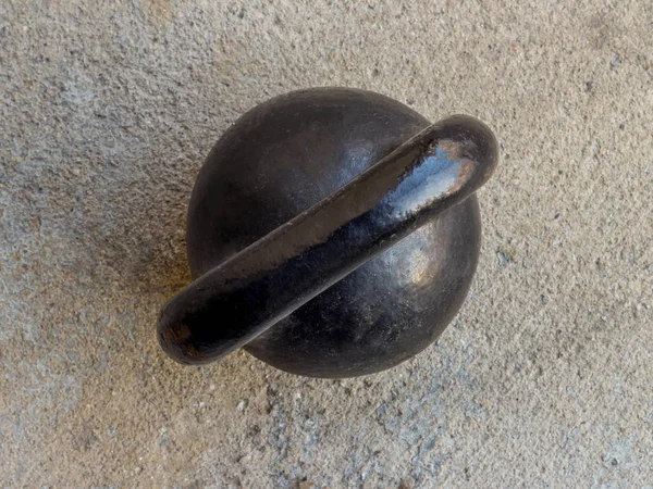 Velho kettlebell preto enferrujado no fundo do chão noncrete — Fotografia de Stock