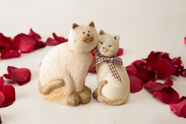 Ceramic cats couple in love with rose petals