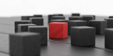 Siyah masa arka planında siyah tahta küpler benzersizlik ve bireysellik kavramını gösteriyor, bir küp kırmızı renkte.
