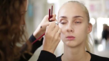 Makyaj sanatçısı bir model üzerinde çalışır