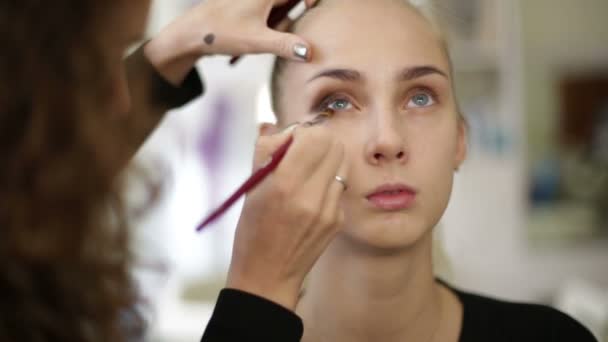 Maquillaje artista trabaja en un modelo — Vídeo de stock