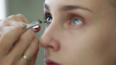 Makyaj sanatçısı modeli bir göz boyar