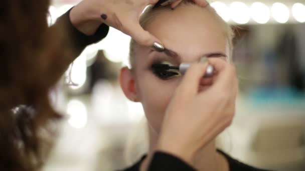 Makeup artist dipinge un occhio del modello — Video Stock