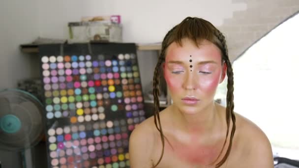 Stylist attach decorative elements to the models face — Stockvideo