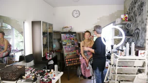 Stylist toe te passen make-up op het gezicht van de modellen — Stockvideo