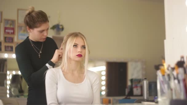 Kadeřník dělá účes blond dívka. — Stock video
