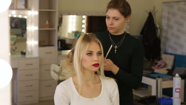 Kapper maakt kapsel blond meisje. — Stockvideo
