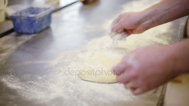 Cook maakt een grote taart deeg voor rollen. — Stockvideo