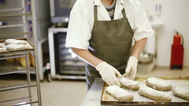 Cocine haciendo cortes en el pan antes de hornear — Vídeo de stock