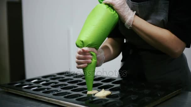 Confectioner fills molds for pastry dough. — Stock Video