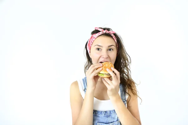 güzel hippi kız hamburger elinde tutan ve gülümseyerek. Beyaz arka plan üzerinde izole modeli