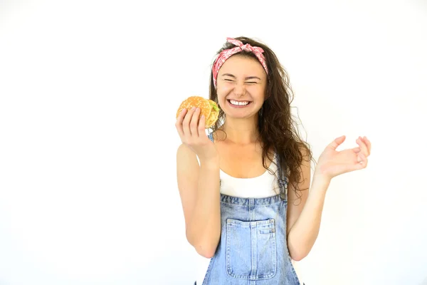 güzel hippi kız hamburger elinde tutan ve gülümseyerek. Beyaz arka plan üzerinde izole modeli