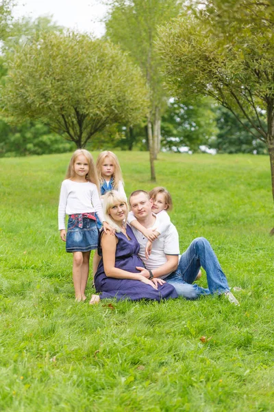 Jovem mãe grávida com sua família em um parque — Fotografia de Stock