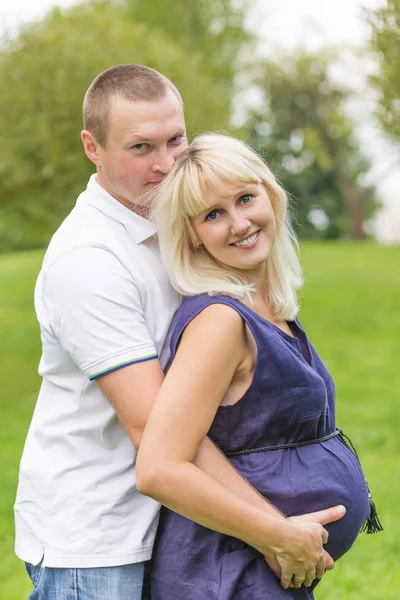 Молода вагітна мати зі своєю сім'єю в парку — стокове фото