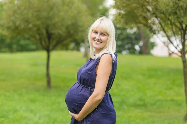 Jeune femme enceinte se reposant dans un parc — Photo