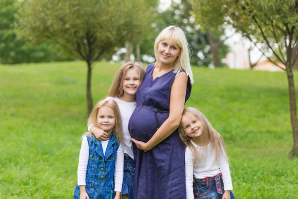 공원에서 그녀의 가족과 함께 젊은 임신 어머니 — 스톡 사진